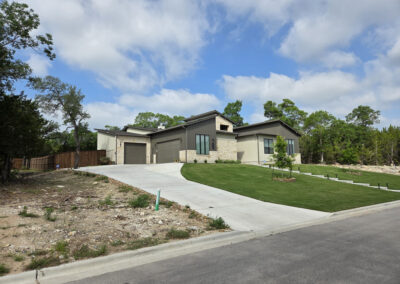 Custom home under construction with house wrap visible, framed roofline, and contractor truck on site