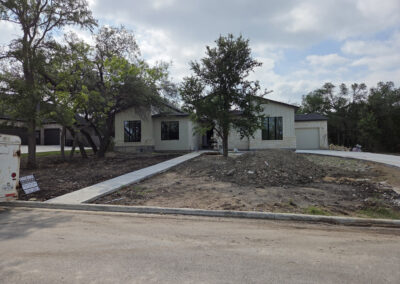 Modern transitional home with brick and stucco exterior, two-tone roof, and large front-yard tree
