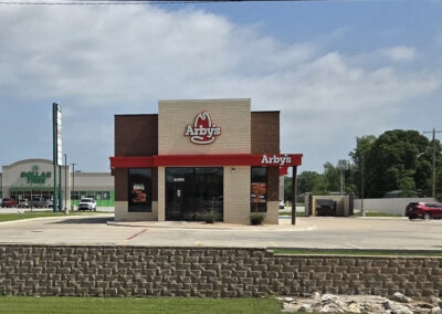 Quick-service restaurant building with red awning, drive-through lane, and concrete approach