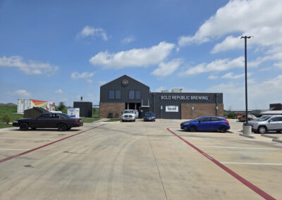 Wide-angle view of a dark commercial building with multiple service bays and an asphalt parking lot