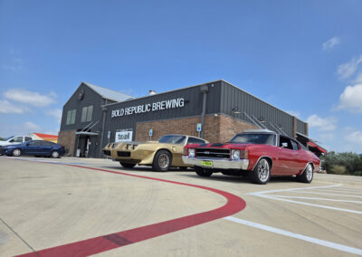 Dark gray industrial commercial building with metal roof and customer parking area
